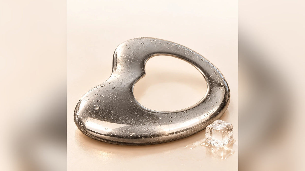 Gua sha de acero en forma de corazón con cubitos de hielo