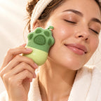 Mujer refrescándose la mejilla con el molde de hielo verde en forma de pata