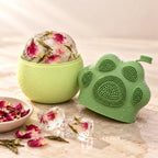 Molde de hielo abierto con un bloque de hielo con pétalos de rosa y té verde