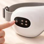 Dedo pulsando el botón del panel de control de las gafas de masaje para ojos