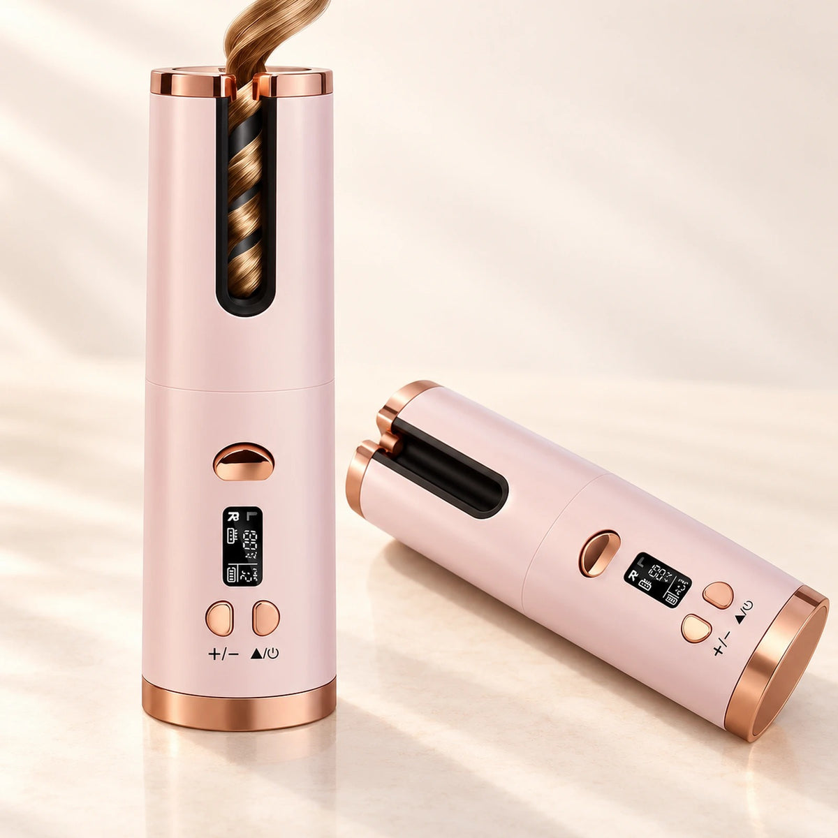 Dos rizadores automáticos rosa y oro rosa, uno con un mechón rizado